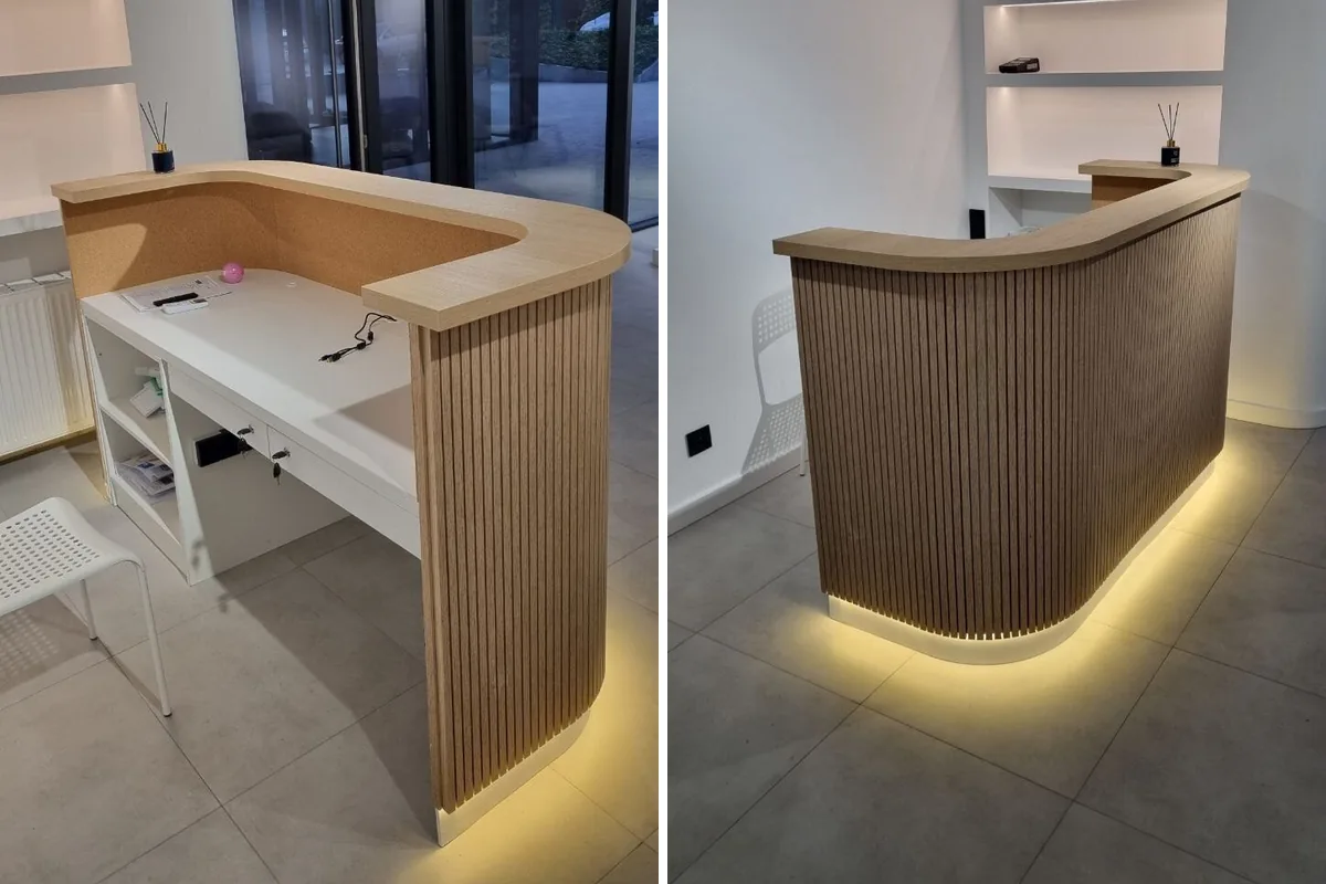 Curved reception desk with slats: on the left the staff side with a white worktop below the guest shelf, drawers and shelves; on the right the guest-facing front with a lit plinth